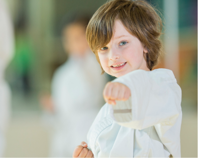 Child smiling with his fist out.