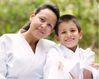 Woman and child smiling in Taekwondo garb