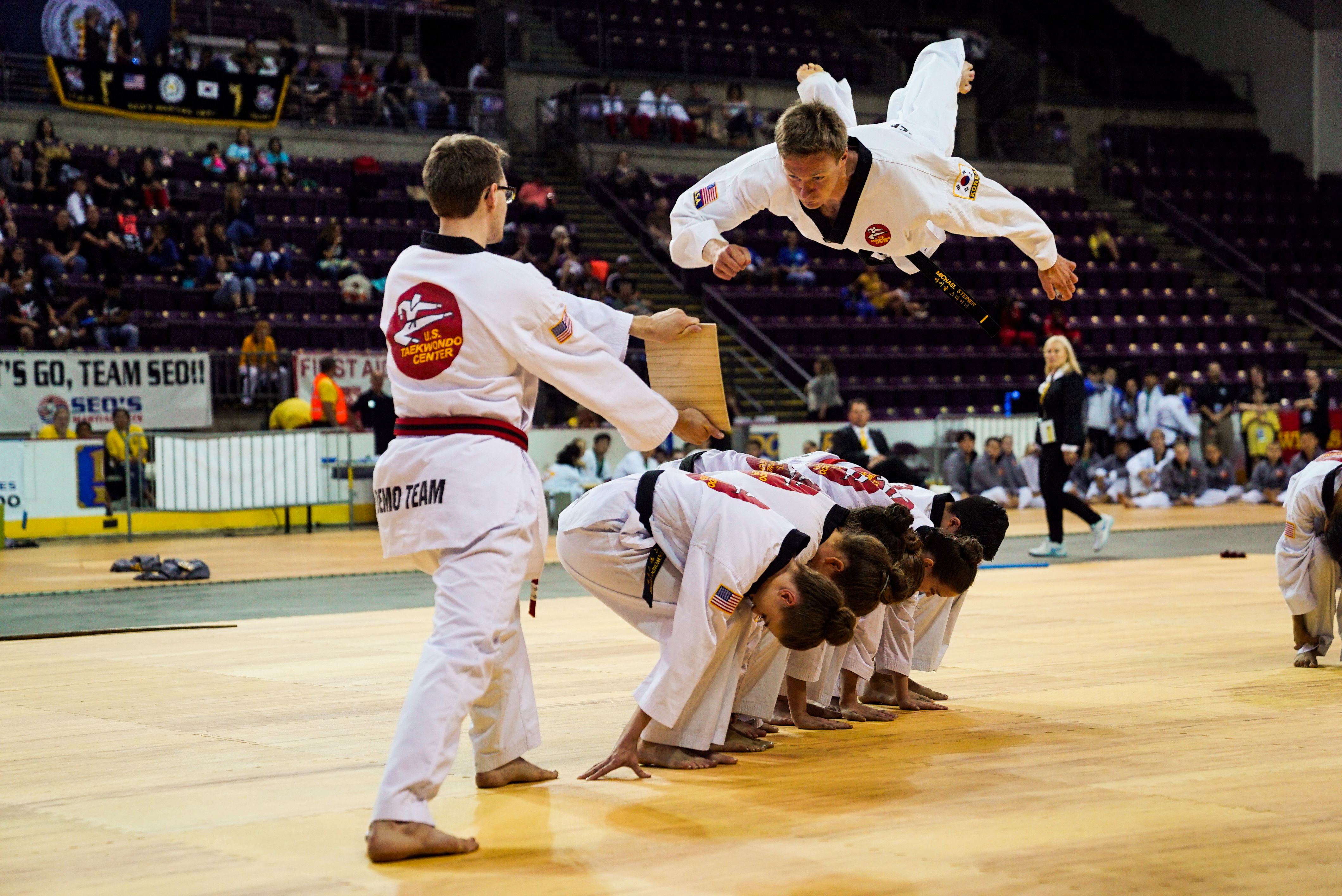 Taekwondo student jumping to punch board